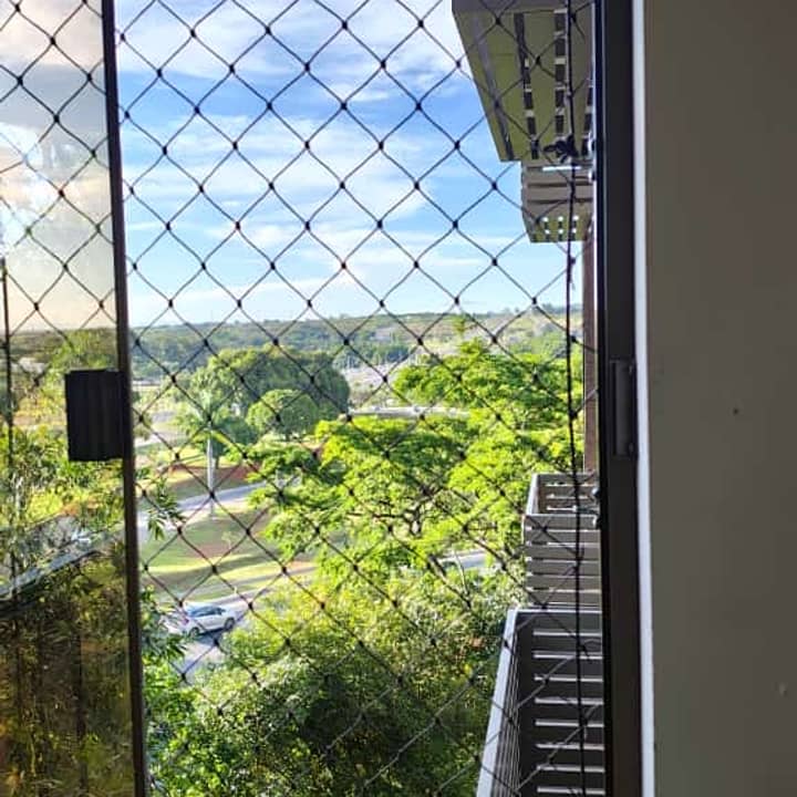 Varanda com rede de proteção e vista para parque